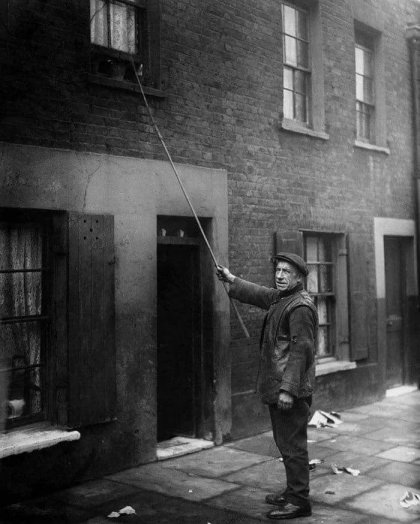 A-Knocker-up-in-London-1929-Before-alarm-clocks-people-were-paid-to-wake-clients-up-for-work-by-knocking-on-their-doors-and-windows-with-a-stick.jpg