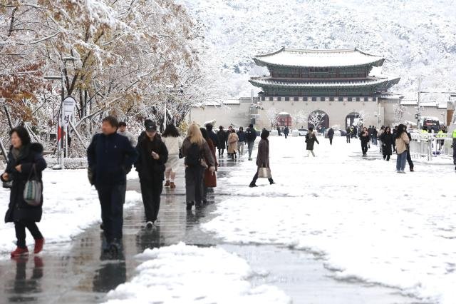 Pedestrians walk along a snow-covered street in Gwanghwamun central Seoul on Nov 27 2024 AJP Han Jun-gu